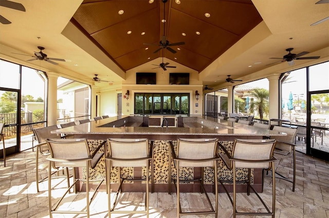 bar featuring stone counters and lofted ceiling