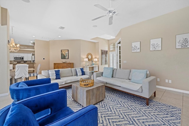 tiled living room with ceiling fan with notable chandelier