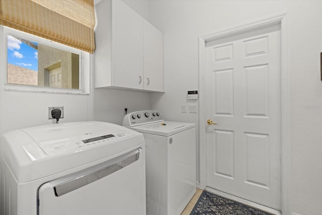 clothes washing area with light tile patterned floors, cabinets, and washer and clothes dryer