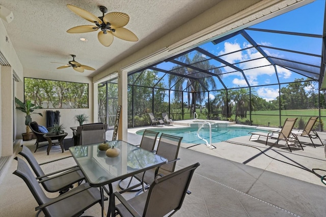 view of swimming pool with ceiling fan, a patio area, and a lanai