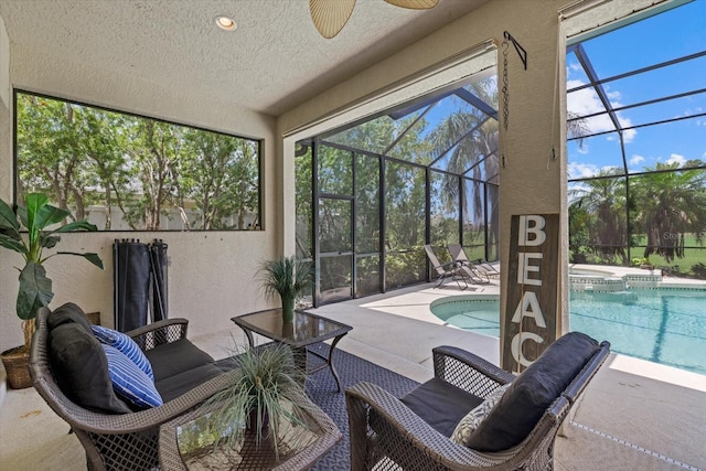 view of swimming pool with glass enclosure, ceiling fan, and a patio