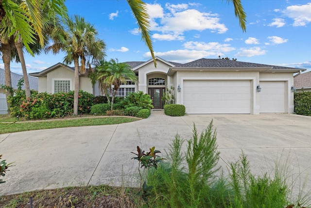 single story home featuring an attached garage, driveway, and stucco siding