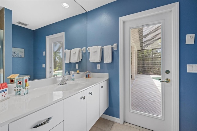 bathroom featuring tile patterned floors, vanity, visible vents, and baseboards