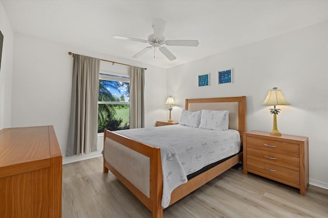 bedroom with light wood-style flooring, baseboards, and a ceiling fan