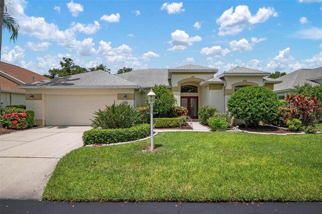 mediterranean / spanish house featuring a garage and a front yard