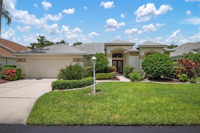 mediterranean / spanish-style house featuring a garage and a front lawn