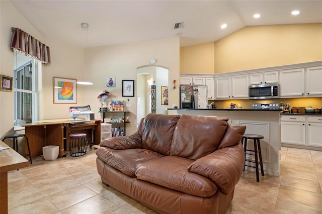 tiled living room featuring high vaulted ceiling