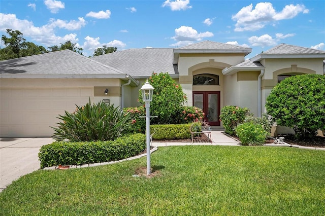 view of front of home featuring a garage, a front lawn, and french doors