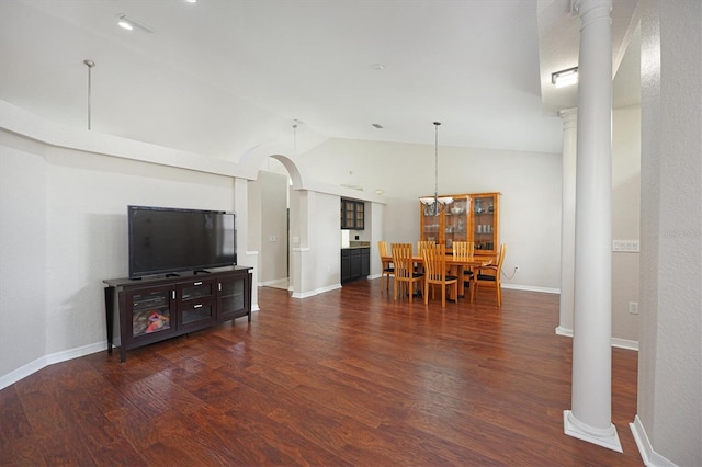 living room featuring decorative columns, dark wood-type flooring, and lofted ceiling