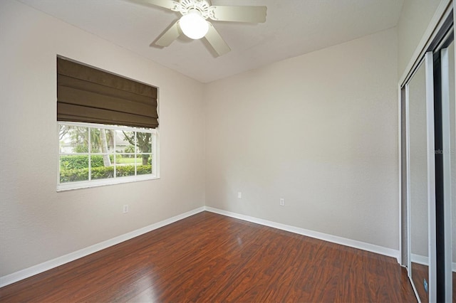 unfurnished bedroom with ceiling fan, a closet, and hardwood / wood-style flooring