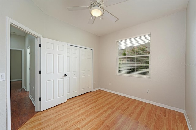 unfurnished bedroom featuring ceiling fan, a closet, and light wood-type flooring