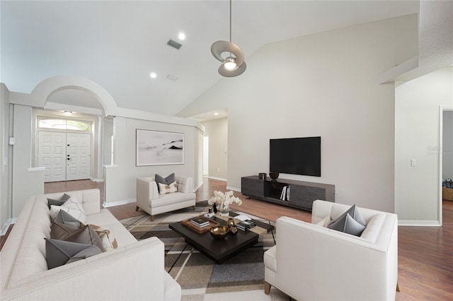 living room with hardwood / wood-style floors and high vaulted ceiling