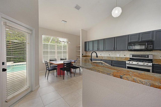 kitchen featuring sink, backsplash, pendant lighting, light tile patterned floors, and stainless steel range with gas stovetop