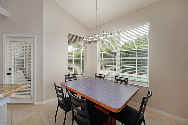 dining room featuring a wealth of natural light, lofted ceiling, and light tile patterned flooring