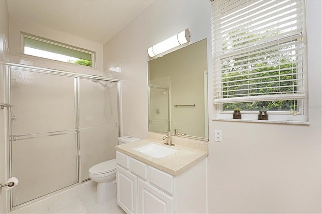 bathroom featuring toilet, vanity, a healthy amount of sunlight, and walk in shower