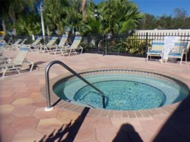 view of swimming pool with a community hot tub and a patio area