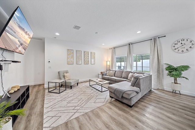 living room featuring a textured ceiling and light hardwood / wood-style flooring