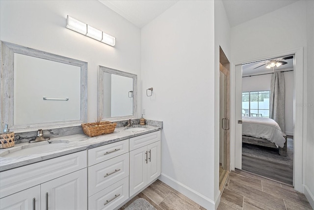 bathroom with ceiling fan, hardwood / wood-style flooring, an enclosed shower, and double vanity