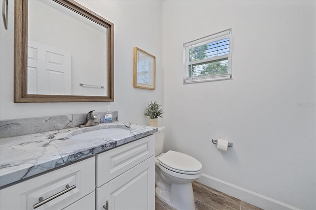 bathroom with vanity, hardwood / wood-style flooring, and toilet