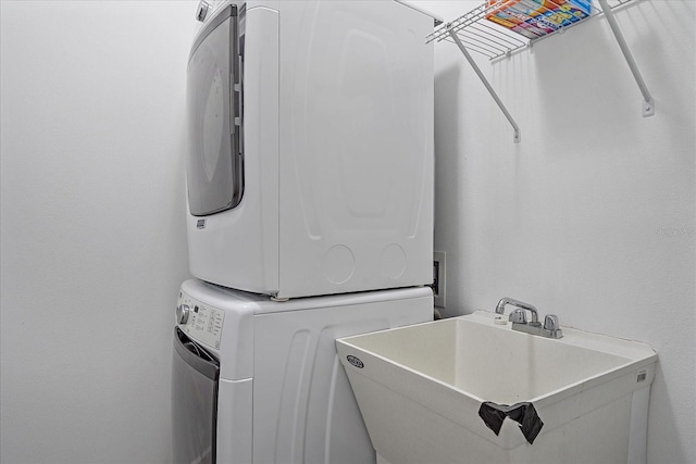 laundry room with stacked washer / drying machine and sink