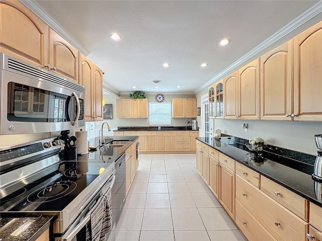 kitchen with appliances with stainless steel finishes, light brown cabinets, sink, light tile patterned floors, and crown molding