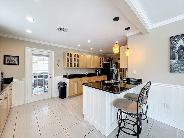 kitchen with sink, kitchen peninsula, a kitchen breakfast bar, and crown molding