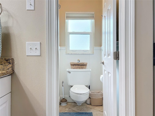 bathroom with toilet, vanity, and tile patterned flooring