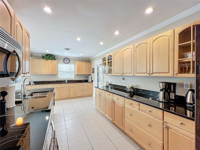 kitchen featuring light tile patterned floors, light brown cabinets, a textured ceiling, crown molding, and sink