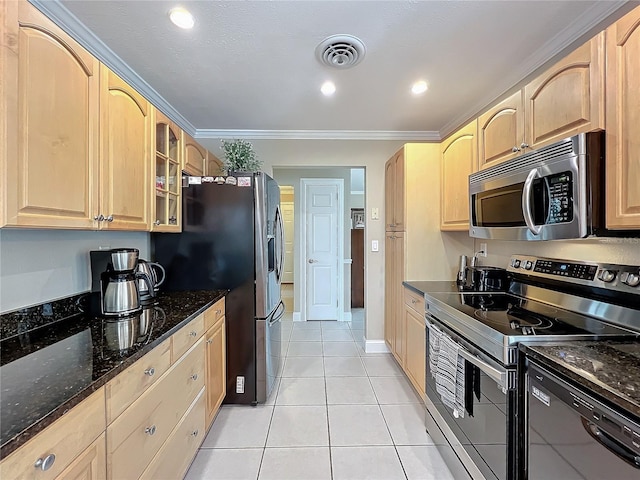 kitchen with light tile patterned floors, stainless steel appliances, light brown cabinets, dark stone counters, and ornamental molding