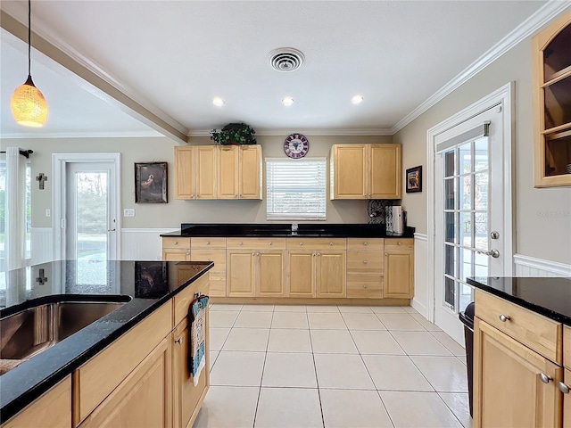 kitchen featuring a healthy amount of sunlight, crown molding, light brown cabinets, and hanging light fixtures