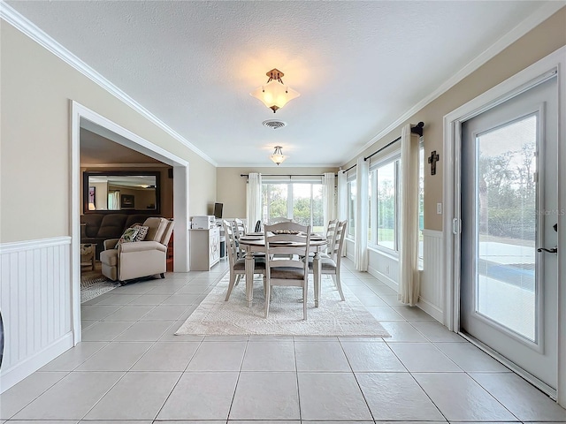 tiled dining room with crown molding and a textured ceiling