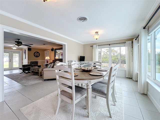 dining area featuring light tile patterned floors, french doors, a healthy amount of sunlight, and ornamental molding