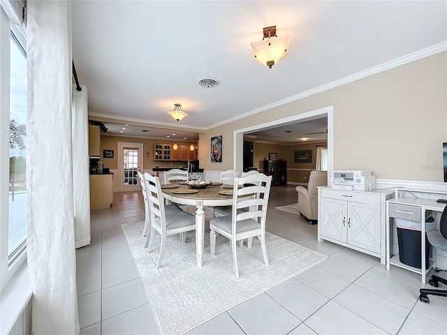 dining room featuring ornamental molding and light tile patterned flooring