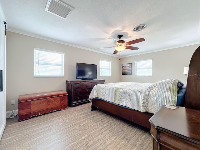 bedroom featuring ceiling fan, crown molding, and light hardwood / wood-style flooring