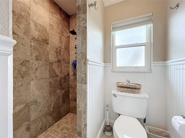 bathroom featuring tiled shower and toilet