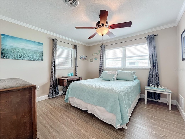 bedroom with light wood-type flooring, ceiling fan, crown molding, and a textured ceiling