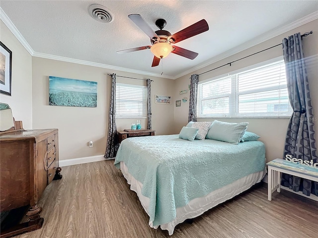 bedroom featuring a textured ceiling, ceiling fan, ornamental molding, and hardwood / wood-style floors