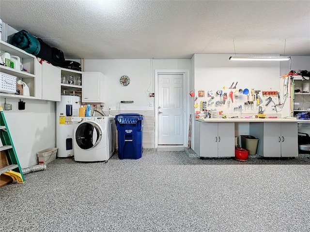 laundry room featuring a textured ceiling, electric water heater, washer / clothes dryer, and a workshop area