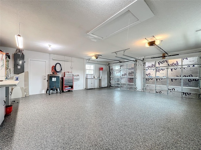 garage featuring electric panel and a garage door opener