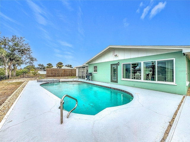 view of pool with glass enclosure, a patio area, and a grill