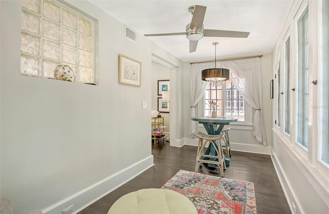 interior space with dark hardwood / wood-style flooring and ceiling fan with notable chandelier