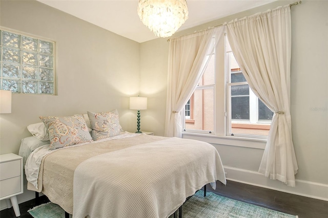 bedroom with an inviting chandelier and wood-type flooring