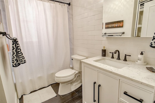 bathroom with hardwood / wood-style floors, decorative backsplash, vanity, toilet, and a shower with shower curtain