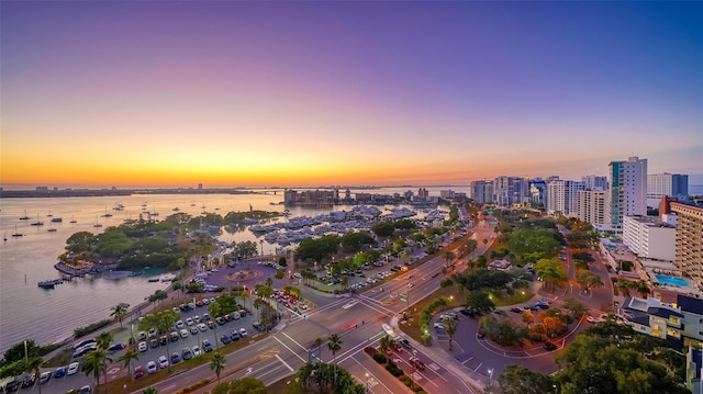 aerial view at dusk featuring a water view