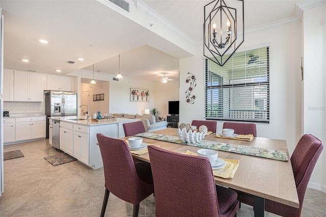 tiled dining room featuring sink, ceiling fan with notable chandelier, and crown molding