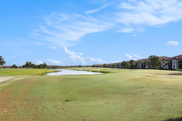 surrounding community featuring a water view and a lawn