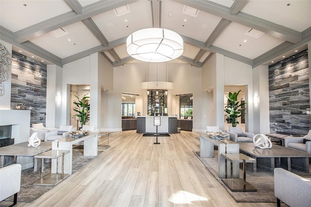 living room with light hardwood / wood-style floors, a high ceiling, and a large fireplace