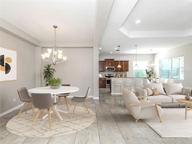 dining room with a chandelier, light tile patterned floors, recessed lighting, baseboards, and a tray ceiling