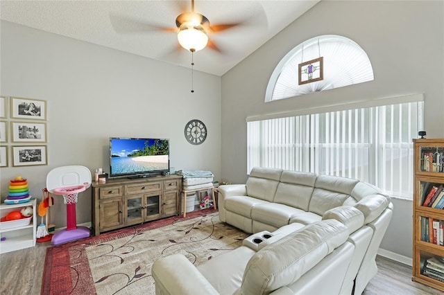 living room featuring lofted ceiling, ceiling fan, and light hardwood / wood-style flooring