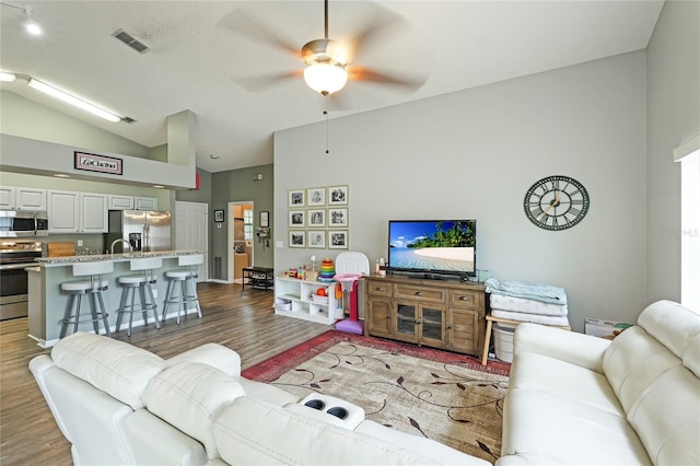 living room featuring lofted ceiling, dark hardwood / wood-style floors, and ceiling fan